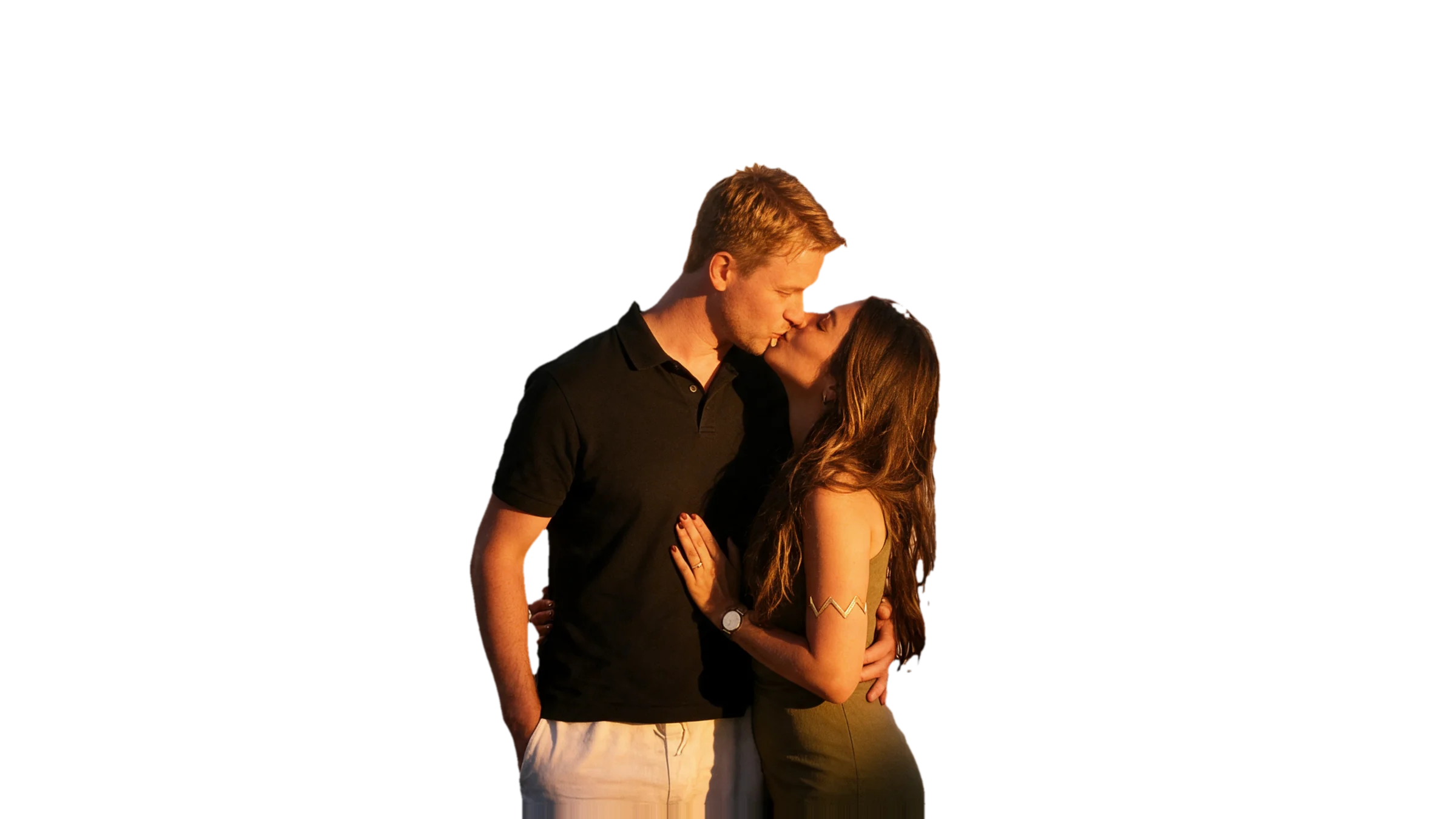 Jen and Stijn kissing at sunset above the sea
